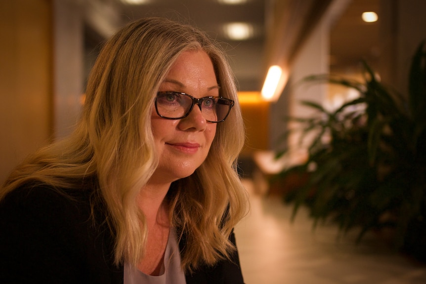 A woman with long hair and glasses.