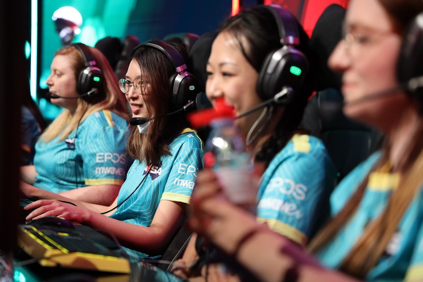 Women wear headphones while playing competitive esports.