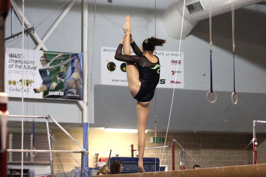 A girl practising gymnastics on a high beam