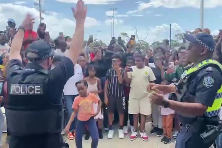 Police officers dance with African community at SA soccer event