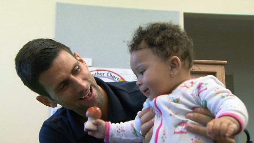 Novak Djokovic plays with a child