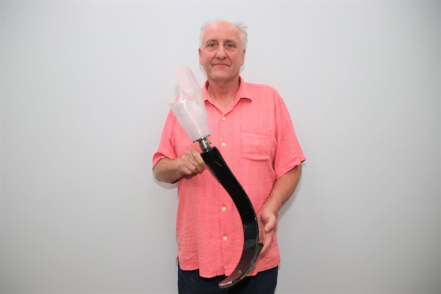 Neil Greening standing holding a blade prosthetic. Ausnew Home Care, NDIS registered provider, My Aged Care