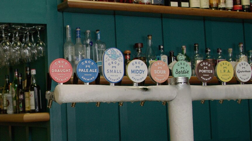 A line of beer taps behind a bar.