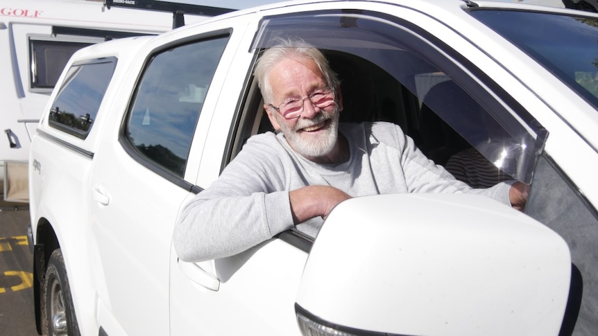 Man in car towing a caravan.