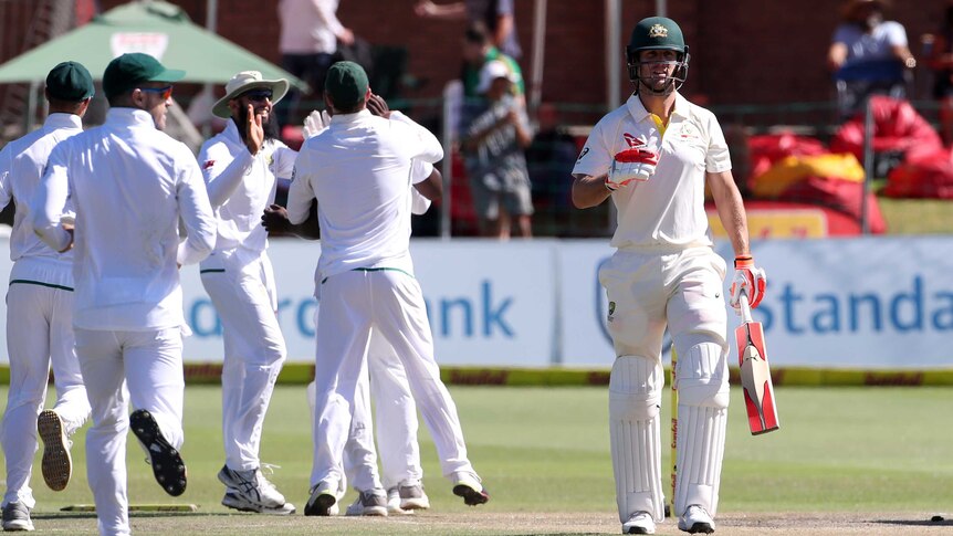 Mitchell Marsh walks off as South Africans celebrate behind him.