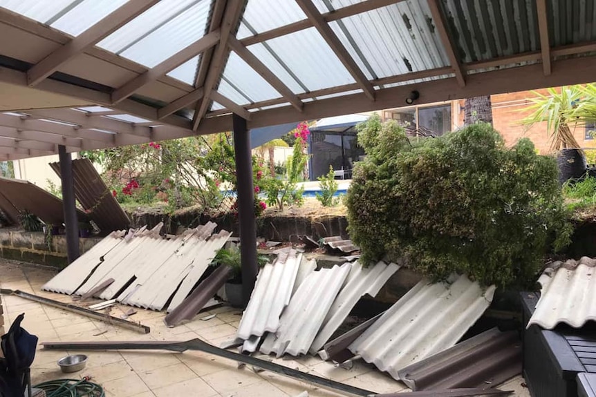 Pieces of fence lie under a patio roof.