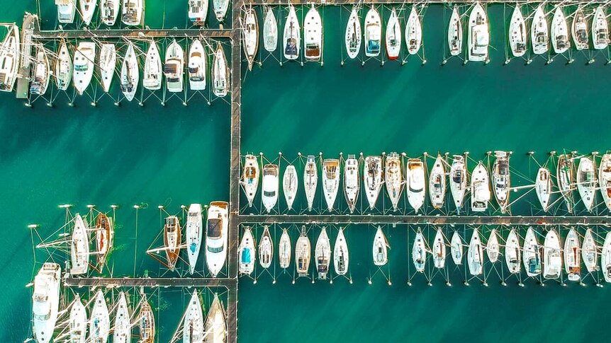 A drone photo of boats moored in a marina.