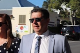 Andrew Antoniolli, wearing sunglasses, walking into court with wife.