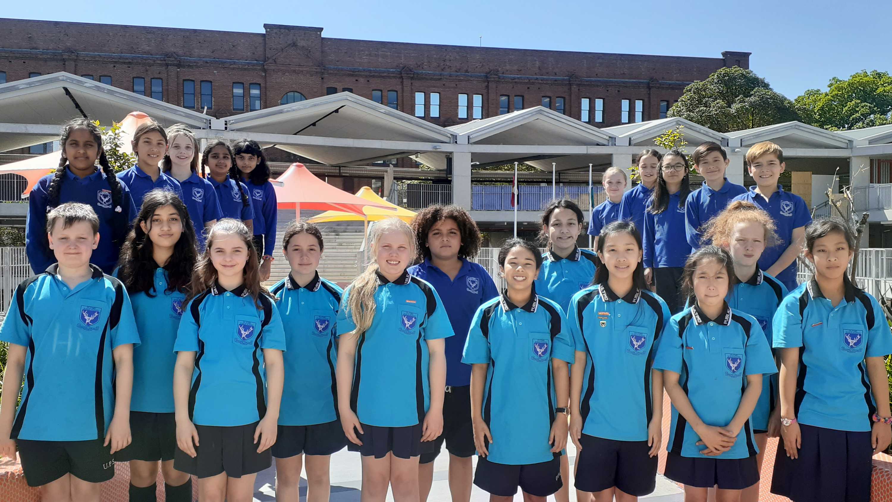 Twenty-two students from Ultimo PS pose in their yard for a photograph.