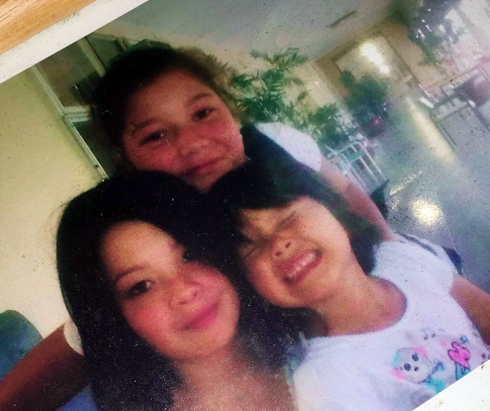 three young sisters smile and look at the camera