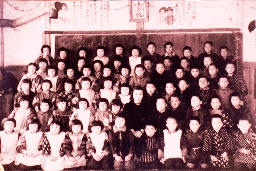 A black and white photograph of Kay Fisher and the students she taught at a Japanese primary school from 1944 to 1948.