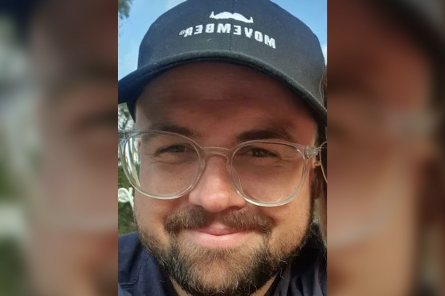 A close up shot of a man wearing glasses and a baseball cap