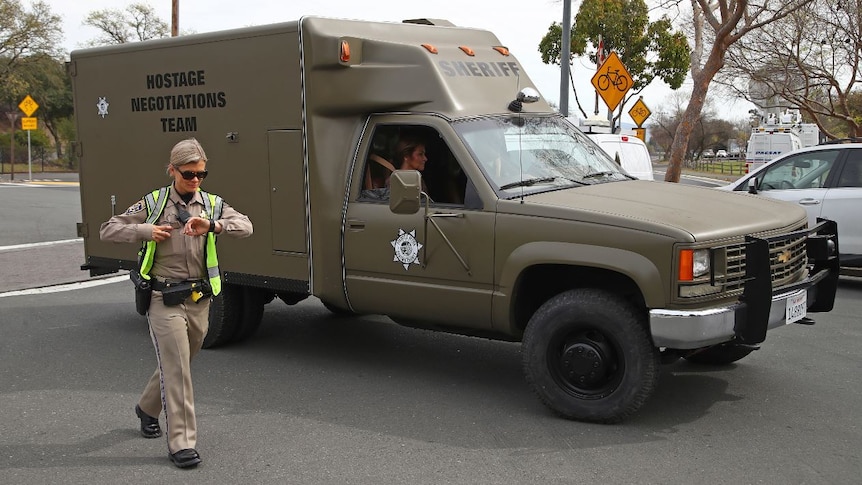 A sheriff's hostage negotiation team passes a California highway patrol checkpoint.