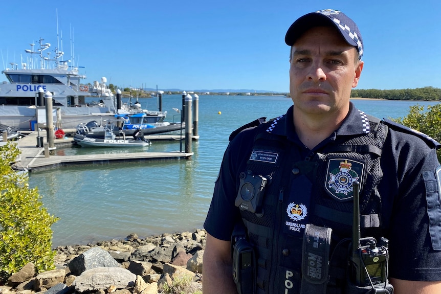 Acting Senior Sergeant Mitch Gray stands outside near boat moorings in Brisbane.