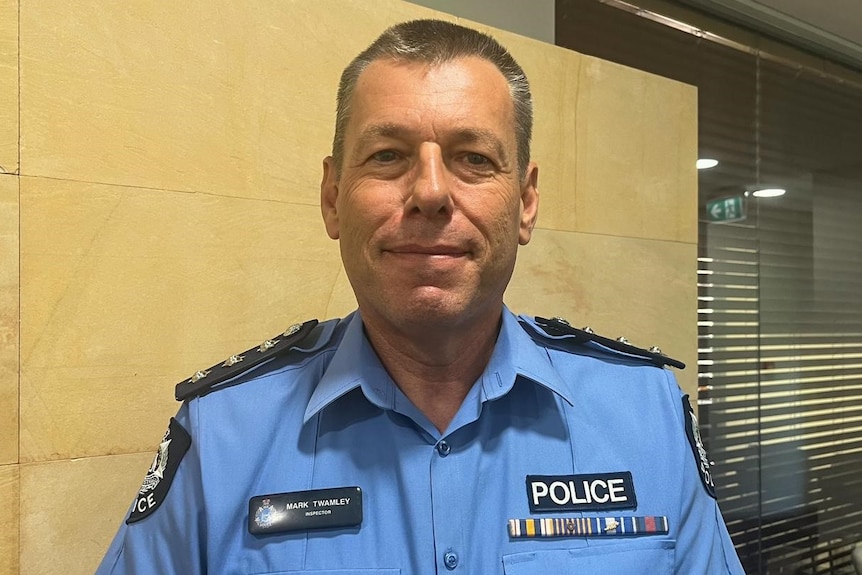 A man smiles at the camera with a WA police uniform