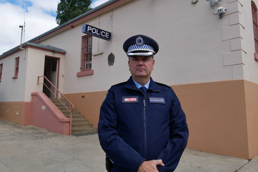 A police officer standing outside of a police station