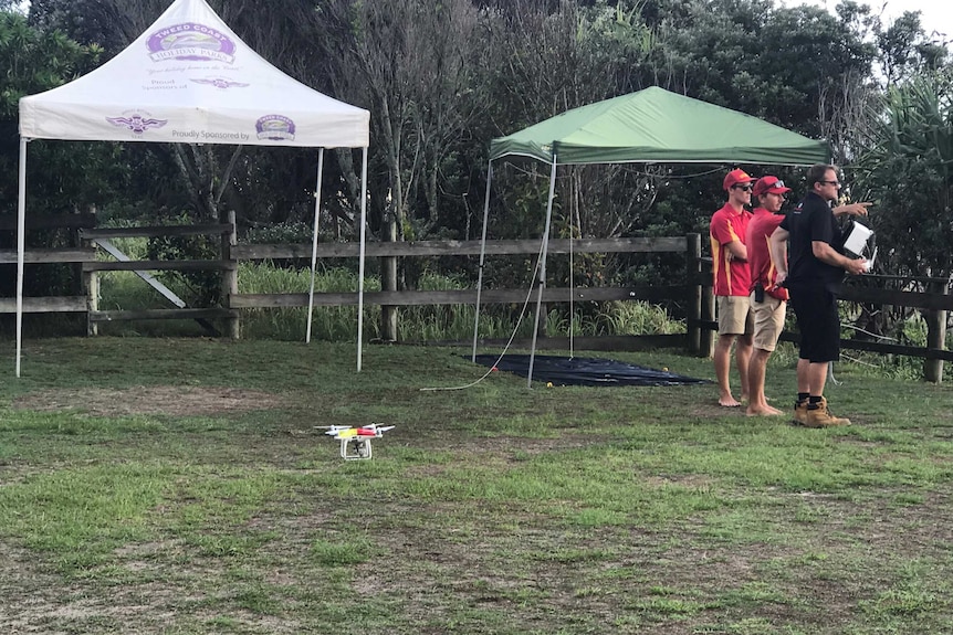 Lifesavers scan the coastline as a drone lands safely back on the beach.