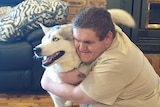 Aaron Lee hugs his support dog 