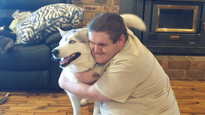 Aaron Lee hugs his support dog 