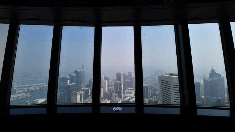 A hazy skyline seen out from the window of a high-rise building.