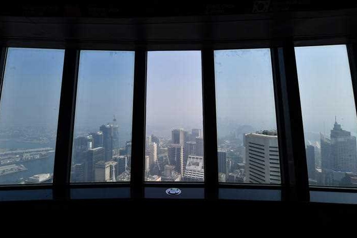 A hazy skyline seen out from the window of a high-rise building.