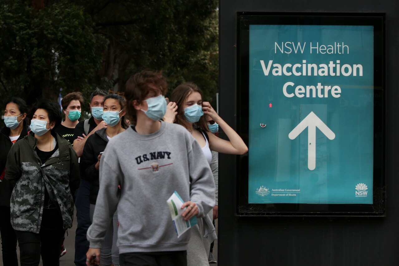 A group of people wearing masks outside a vaccination centre in Sydney.