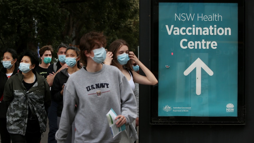 A group of people wearing masks outside a vaccination centre in Sydney.