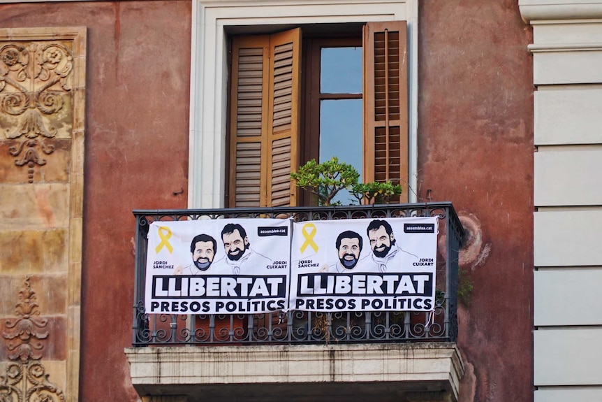 Two election posters on a balcony in Barcelona ahead of the Catalan regional election.