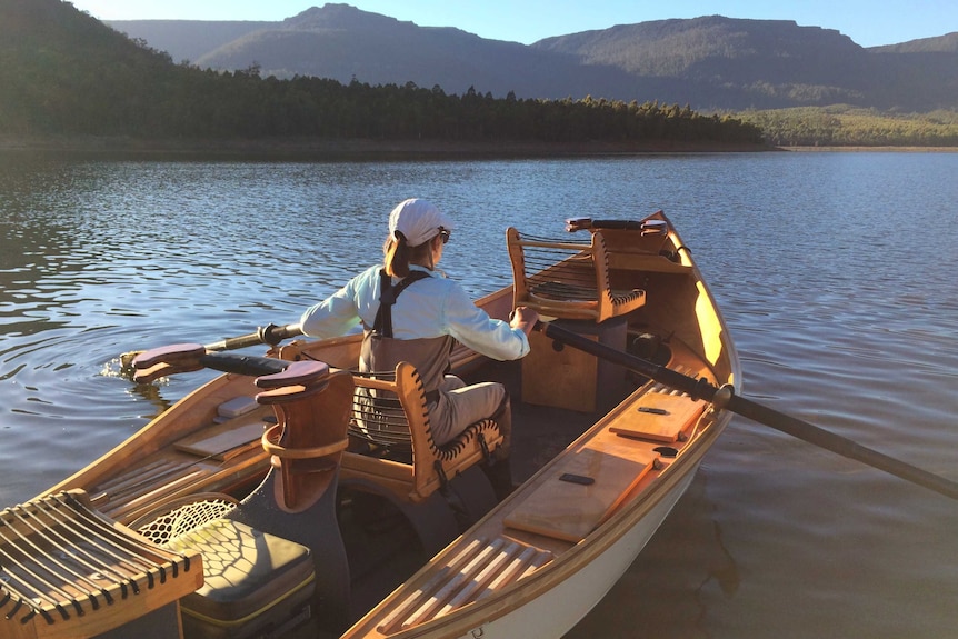 A fisherman rowing on a lake in Tasmania