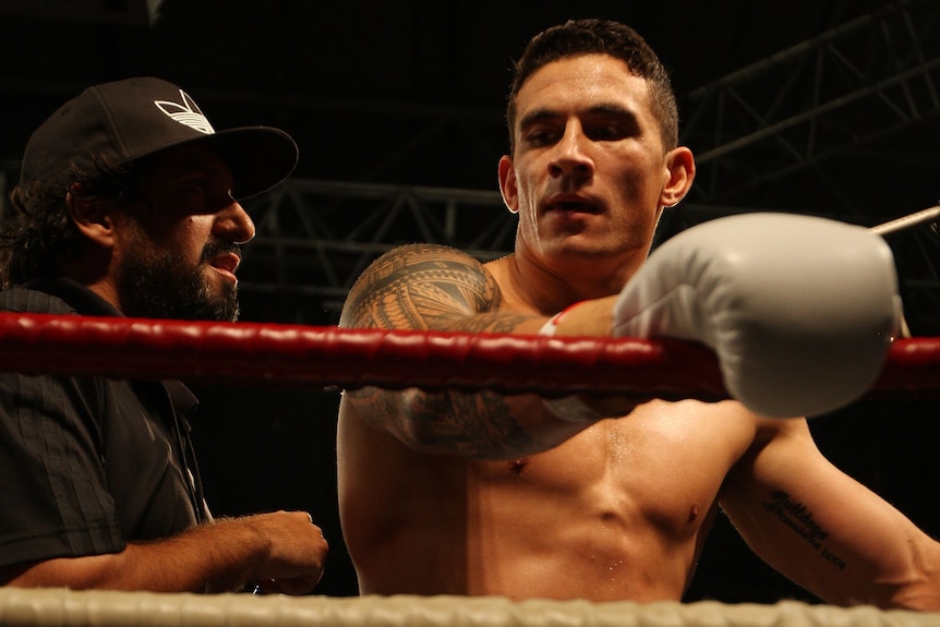 Khoda Nasser speaks to Sonny Bill Williams in the corner of a boxing ring.