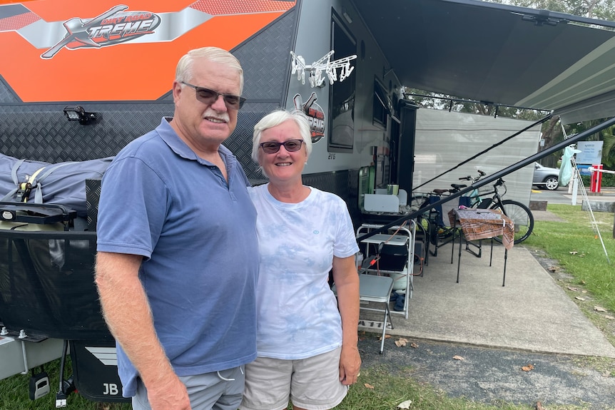 Jill and David Hammon, a Sydney couple in their 60s, pose next to their caravan.
