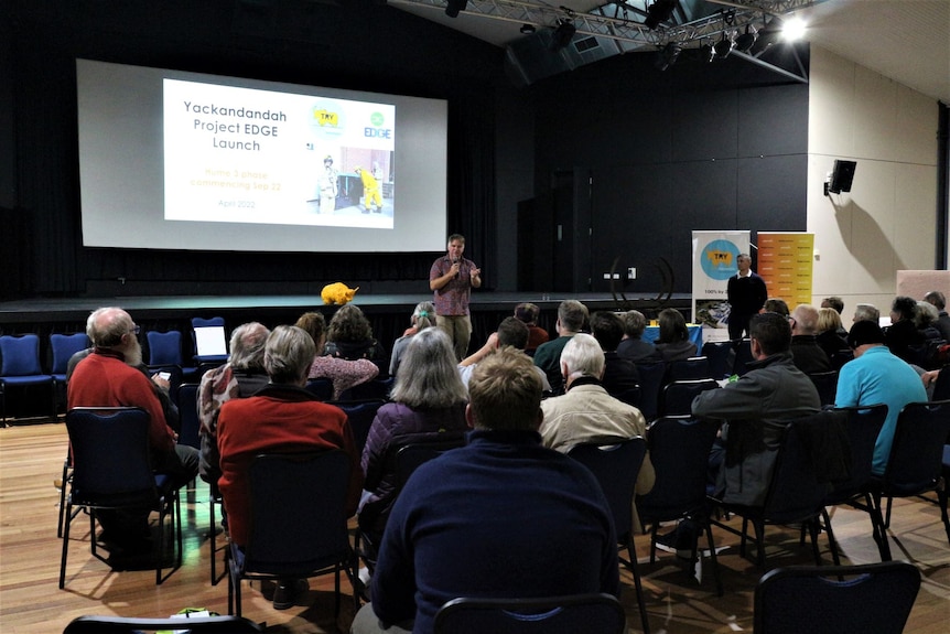 A man speaking in front of a seated crowd. The slide behind him reads Yackandandah Project EDGE Launch