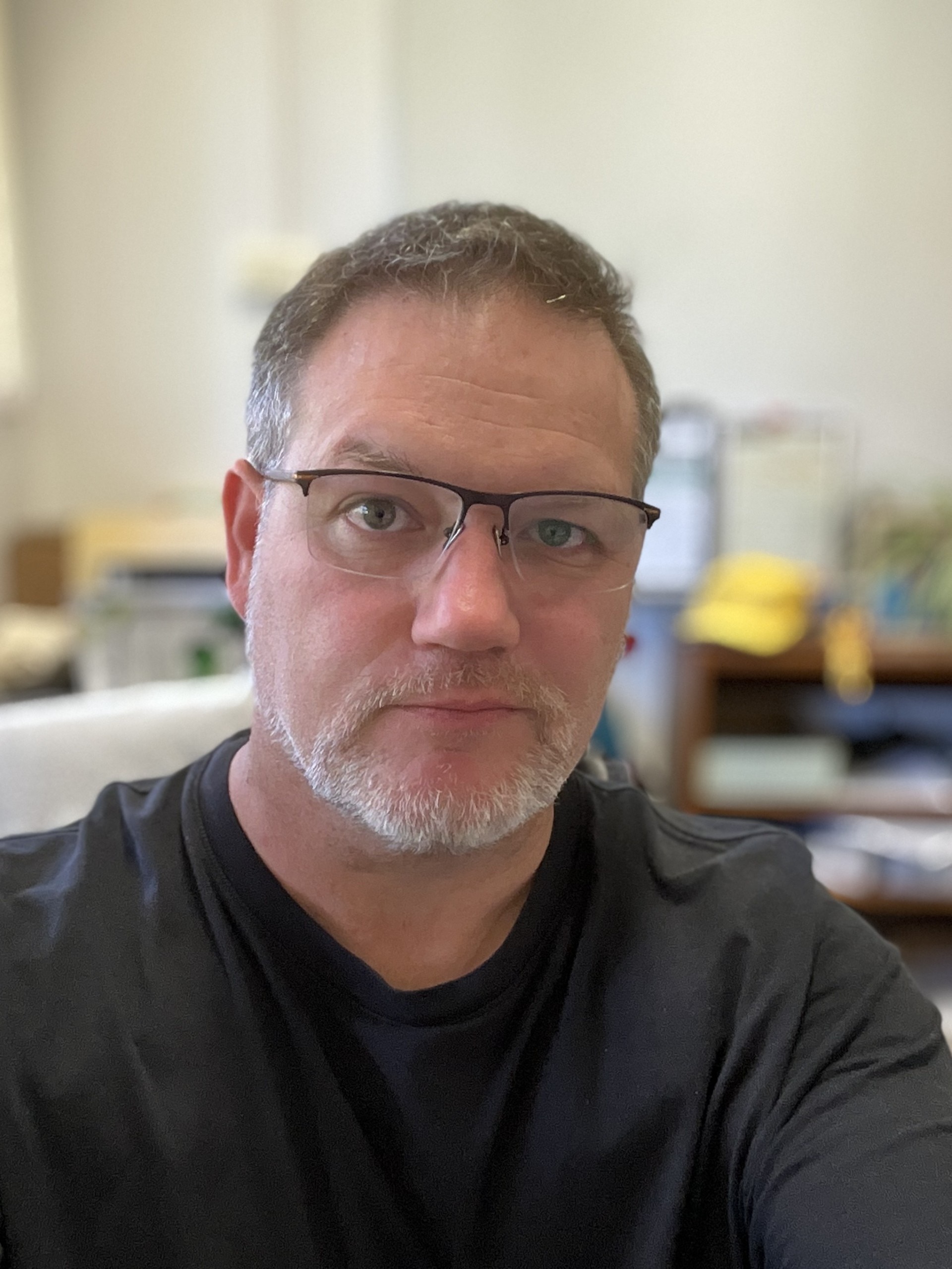 Un hombre con gafas mira a la cámara.