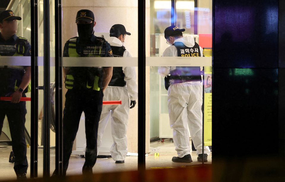 Policemen examine a crime scene inside  