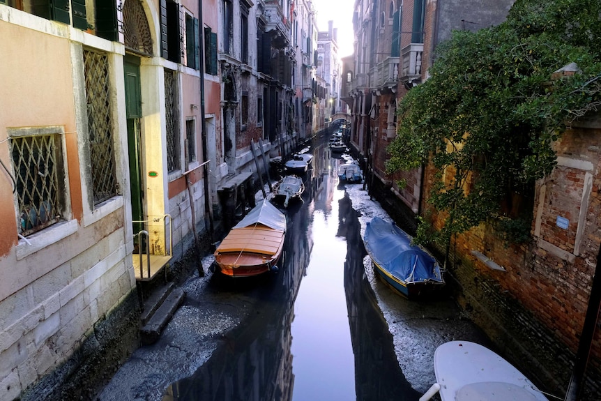 General view of a canal with boats during an exceptional low tide in the lagoon city of Venice.