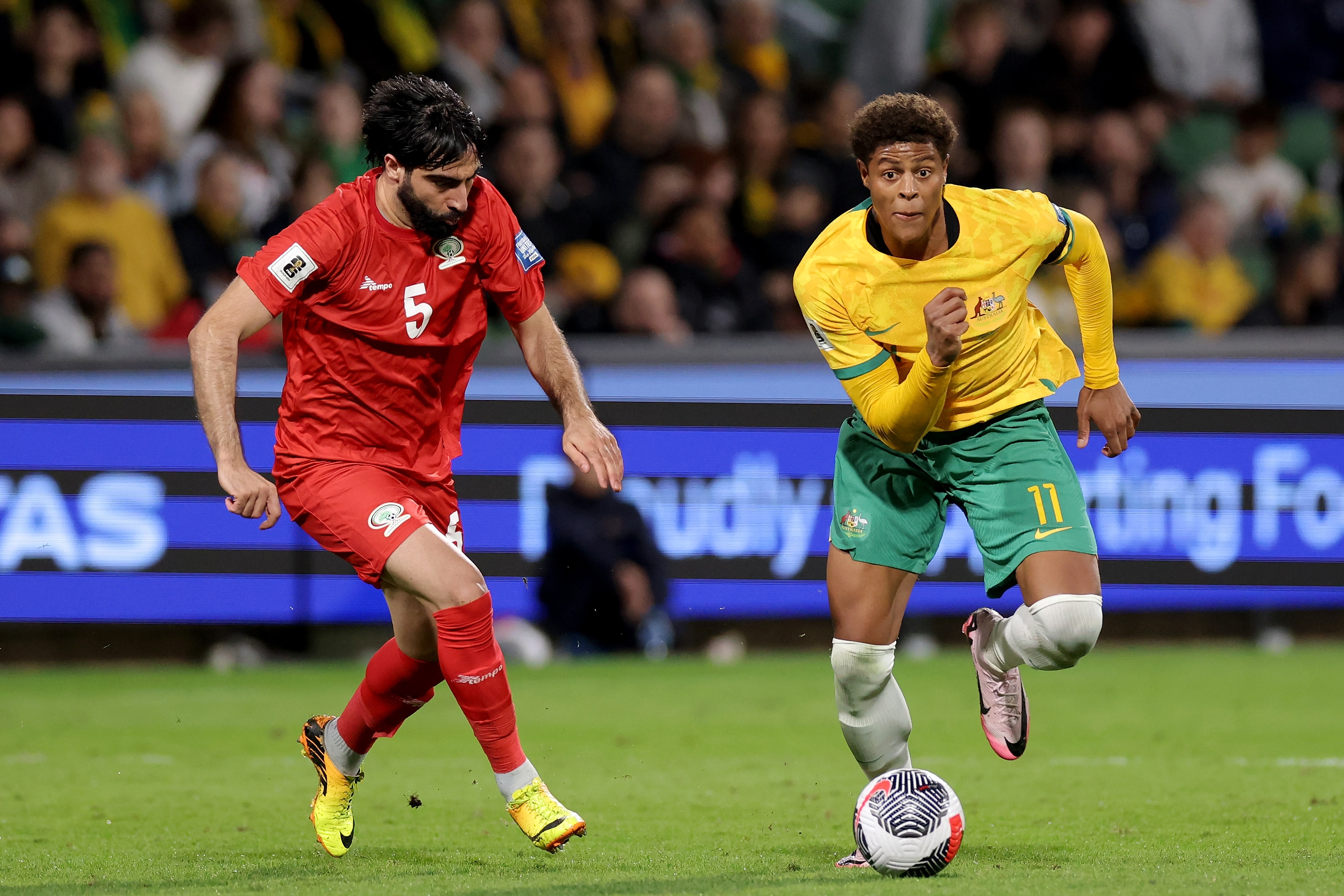 Australia's Kusini Yengi runs with the ball under pressure from Palestine's Mohammed Saleh