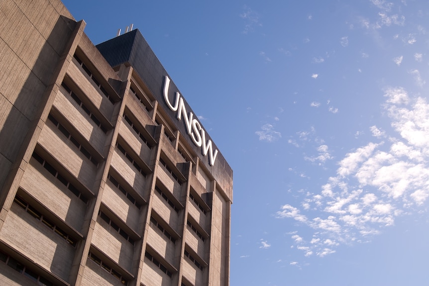 The University of New South Wales (UNSW) library is seen against a bright, cloudy sky