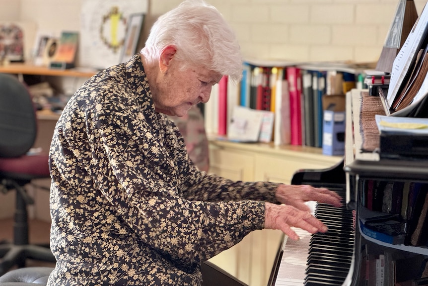An elderly woman playing the piano.
