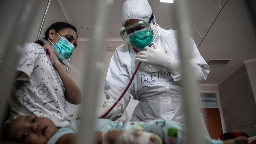 A doctor attends to a baby with COVID-19 at an Indonesian hospital