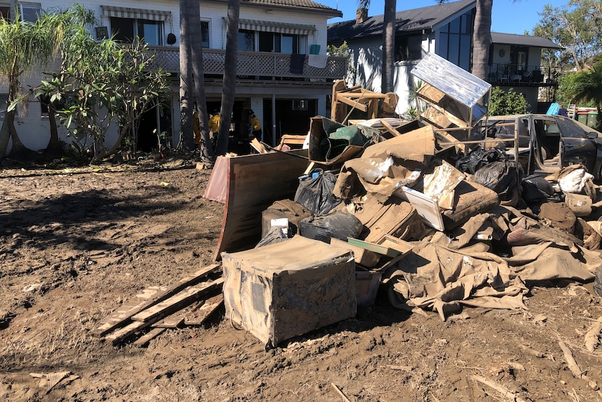 A pile of belongings outside on the mud.
