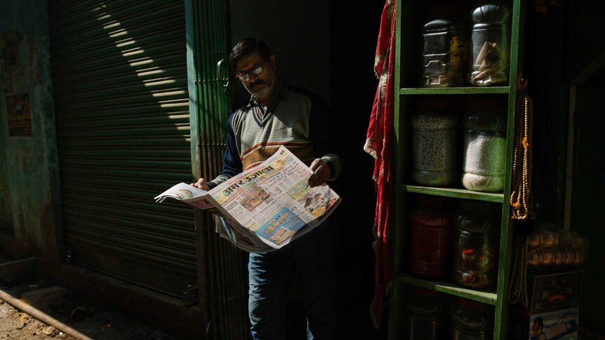 Man reads a newspaper in India