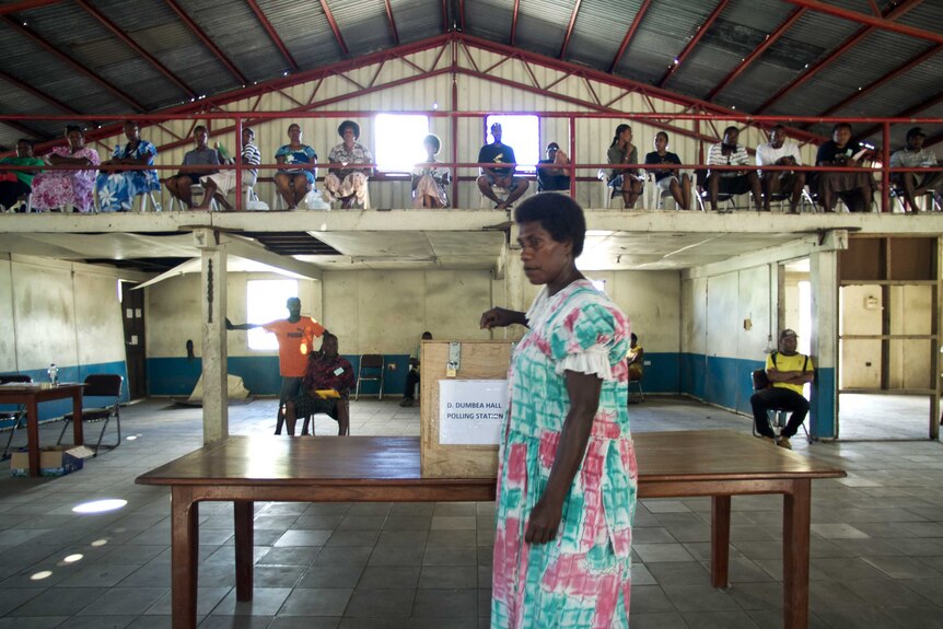 A resident casts her vote at a polling station in Port Vila
