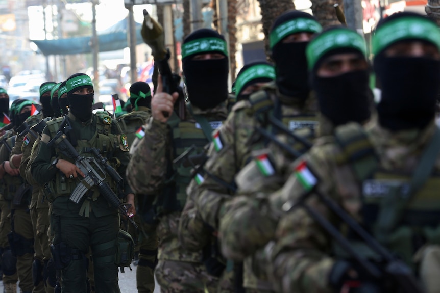 一队手持武器，身穿迷彩服，头戴绿色头带的巴勒斯坦哈马斯武装分子。