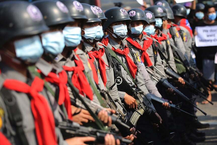 Armed riot police are seen near protesters in Naypyitaw, Myanmar.