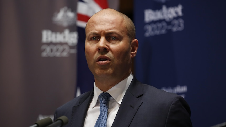 Josh Frydenberg standing in front of budget 2022-23 branding 