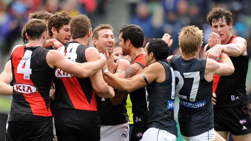 Essendon and Carlton players wrestle at the MCG. The Blues went on to win by 96 points.