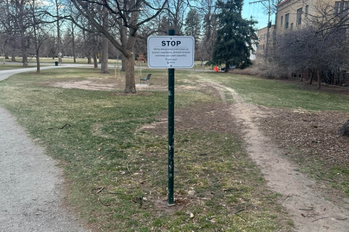 A sign at a park in Denver asking people to stick to the allocated path.