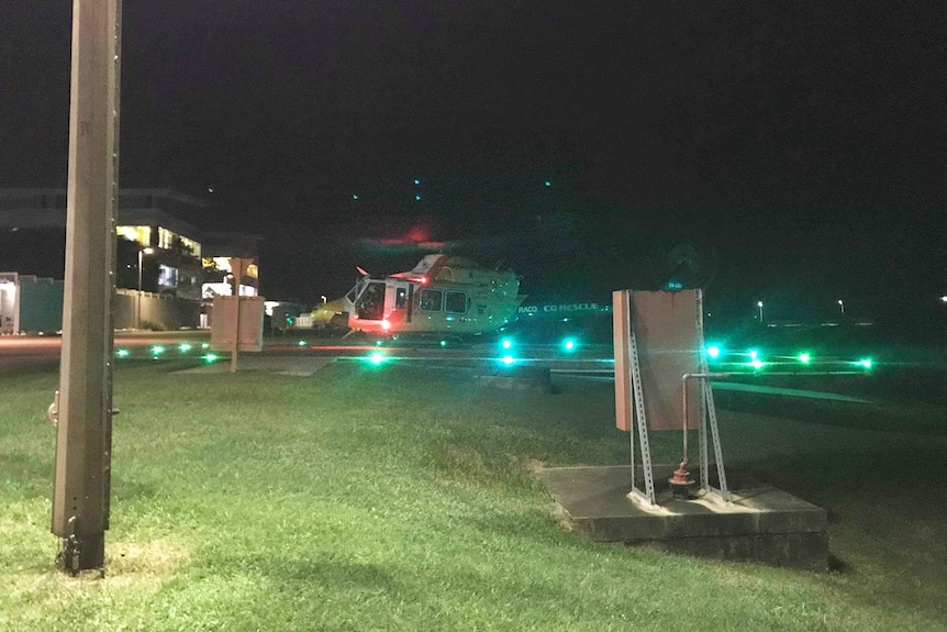 Helicopter lands at Mackay hospital at night.