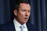 A mid-shot of WA Premier Mark McGowan speaking at a media conference indoors.