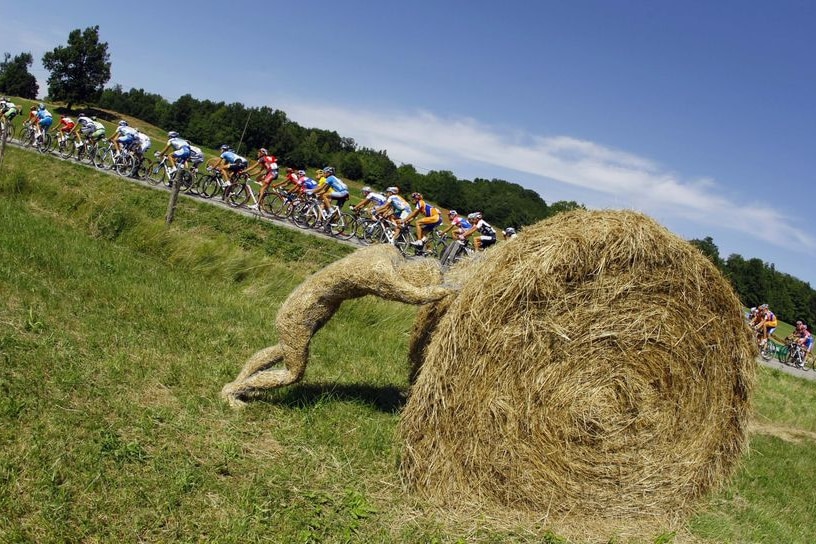 The pack of riders cycle past a hay sculpture during the eleventh stage of the 95th Tour de France (Reuters: Bogdan Cristel)